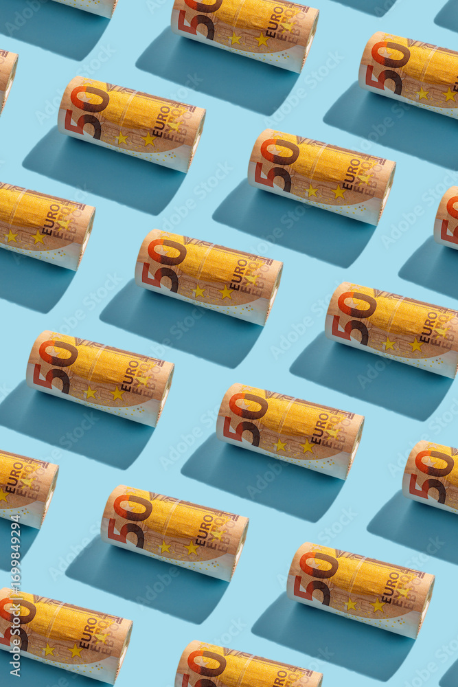 Fifty euro notes rolled in seamless pattern on blue background with copy space