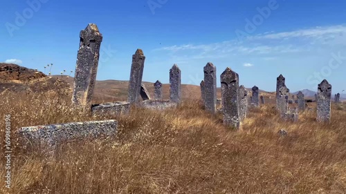 Slow motion of arid field with an ancient cemetery and many tombstones. Old cemetery is located opposite the two-story mausoleum of the Diri Baba Mosque in Gobustan, Azerbaijan.