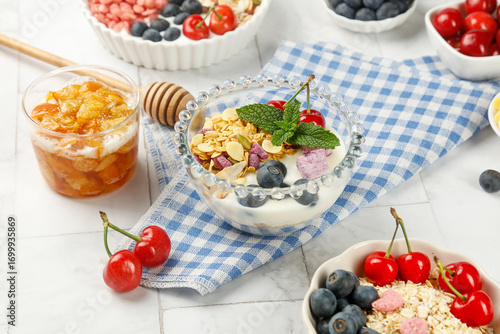 Healthy oatmeal breakfast bowls with fresh fruit berries and honey on white wooden background