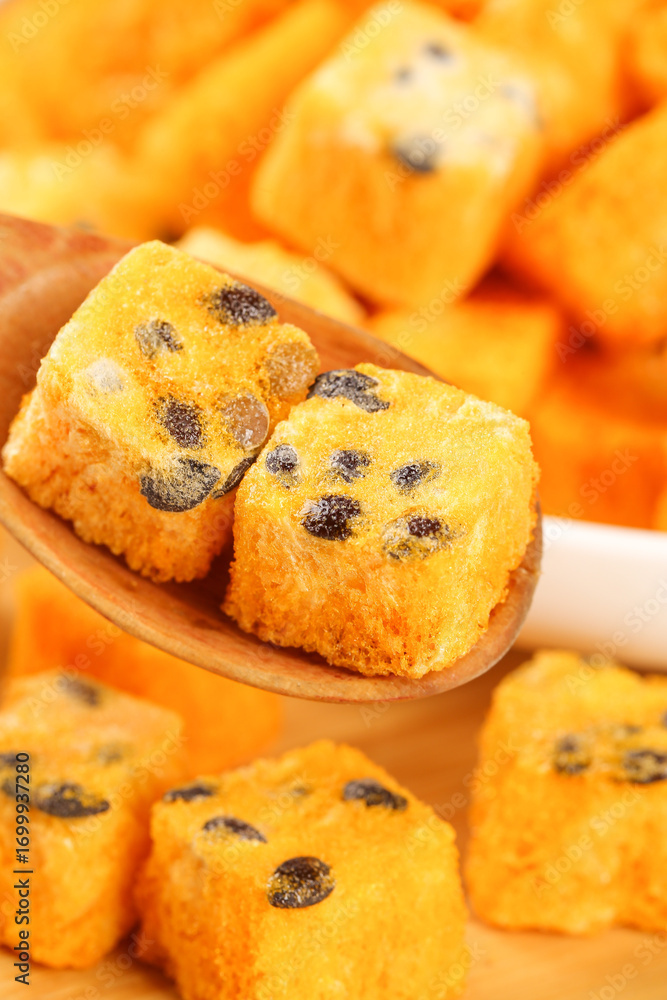 Fototapeta premium Freeze Dried Fruit Cake Blocks with Raisins on Wooden Spoon - Instant Tea Snacks
