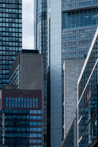 Glass skyscrapers in Frankfurt financial center, vertical facades reflecting modern architecture, symbolizing European corporate power, innovation and contemporary urban identity