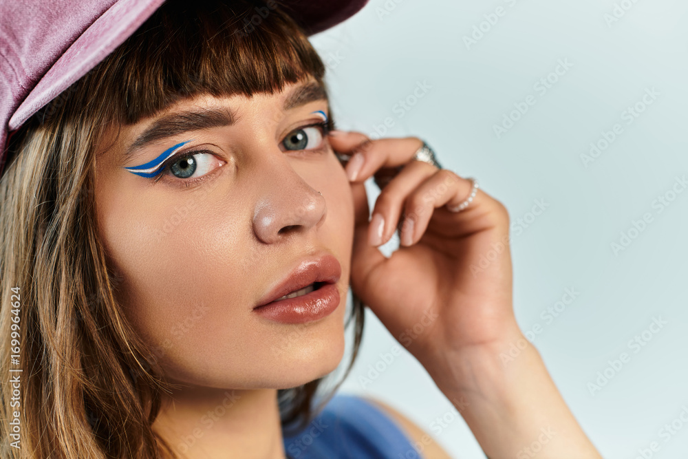 Obraz premium Stylish young woman with unique makeup and fashionable attire showcases modern trends