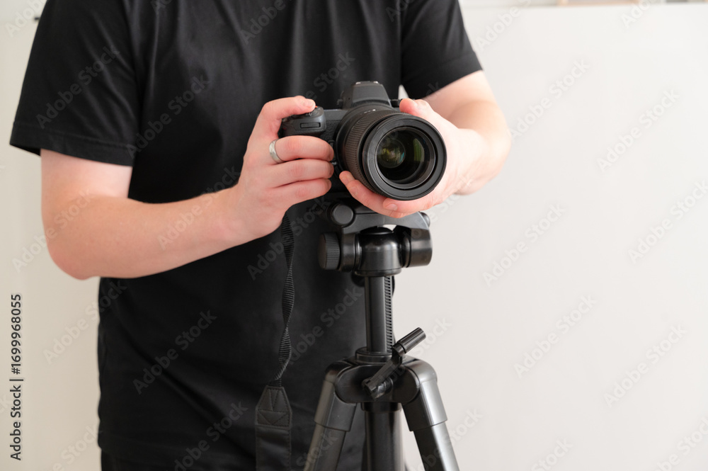 Obraz premium A photographer is meticulously setting up a camera on a sturdy tripod for capturing images