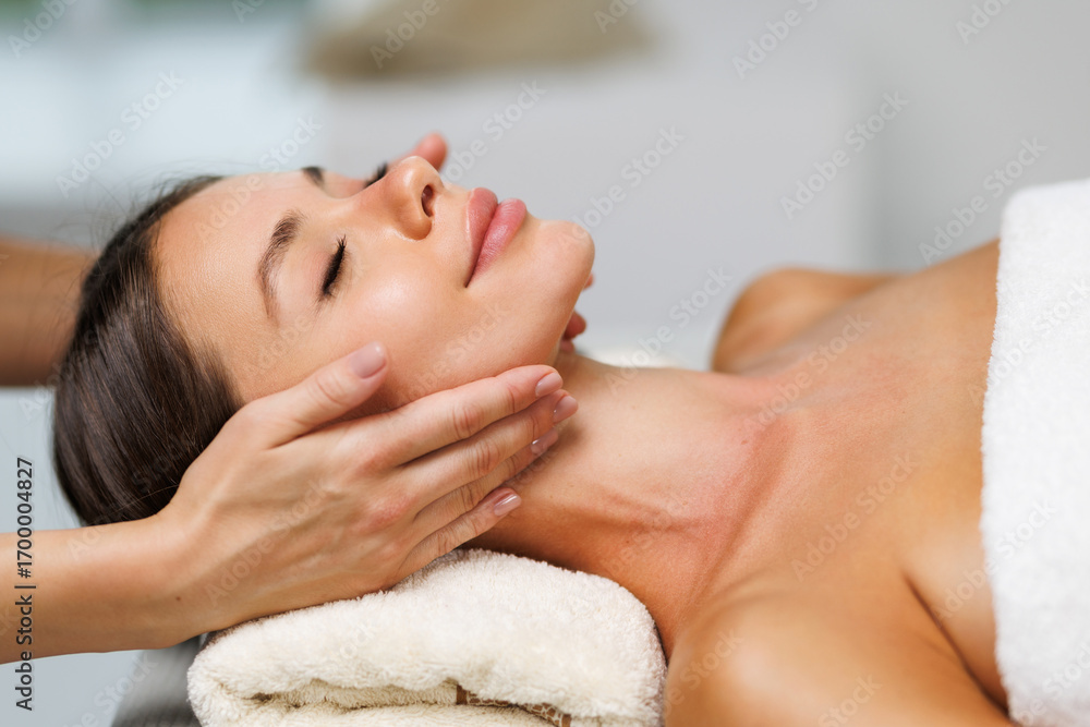 Fototapeta premium Beauty skin, skincare massage in a beauty clinic. Facial lifting massage in SPA salon. A cosmetologist girl does a facial massage.