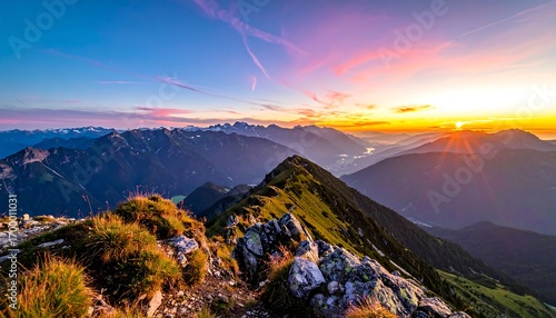 A breathtaking vista of majestic mountains at sunrise, showcasing a dramatic array of colors and a serene atmosphere.