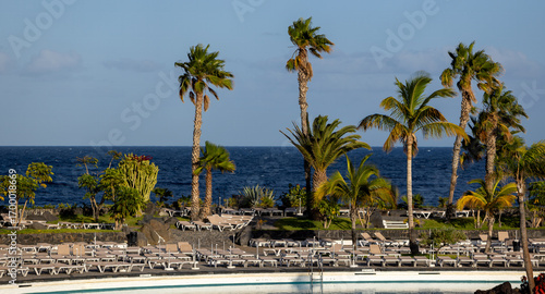 The end of summer. An idyllic resort setting, surrounded by palm trees and the ocean in the background, at the end of the day in September.