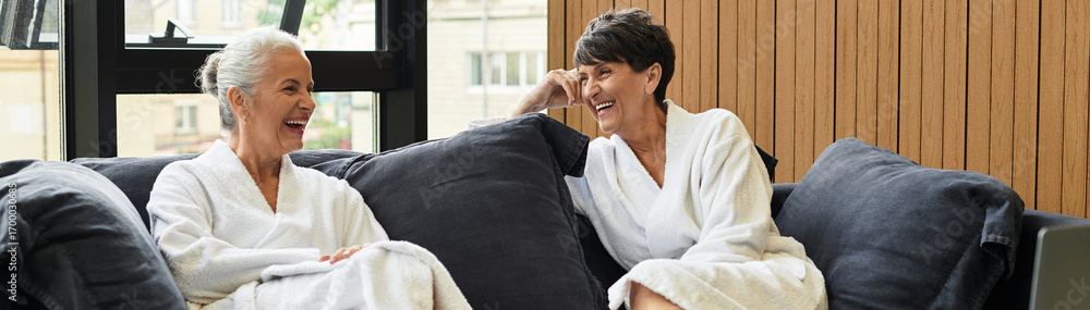 Fototapeta premium Two beautiful mature women enjoy a joyful moment together in a wellness center setting