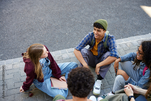 Wallpaper Mural Happy teenager friends sitting and chatting together outdoors Torontodigital.ca