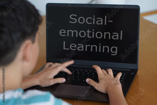 Social and Emotional Learning in Schools Concept. Adolescent Child Using a Laptop with Words Written on the Screen