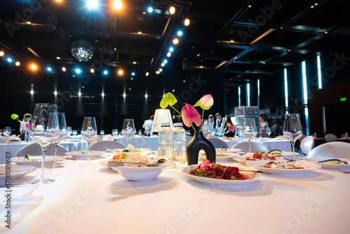 Banquet table served with glasses, food and elegant decoration for wedding or corporate event