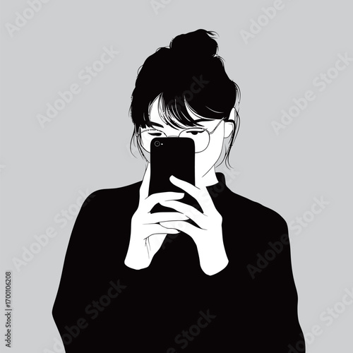 A woman is holding a smartphone in front of her face, capturing a selfie. She has glasses, tied-up hair, and is wearing a black top in a simple environment.