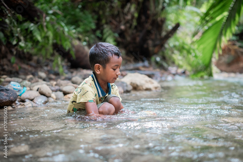 Asian boy is playing in the river