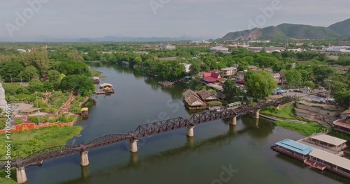 Scenic Aerial View of Iconic River Kwai Bridge in Kanchanaburi Surrounded by Lush Greenery and Tranquil Waters