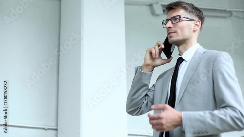 A man in a suit is talking on his cell phone
