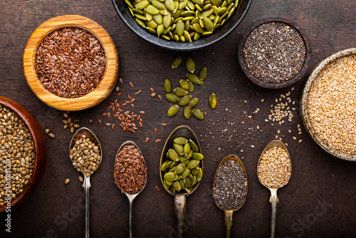 Pumpkin, sesame, flax, hemp, chia seeds in spoons and bowls, seeds for good health of mind and body, enriched with minerals and vitamins. Top view