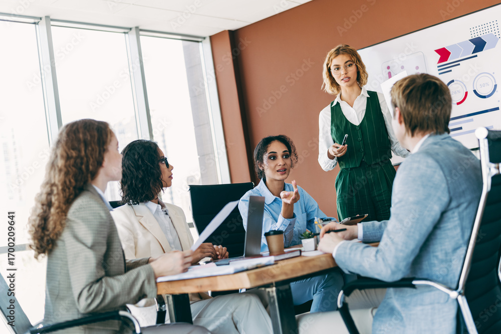 Obraz premium Young professionals collaborating in a modern office during a team meeting focused on organizational strategy