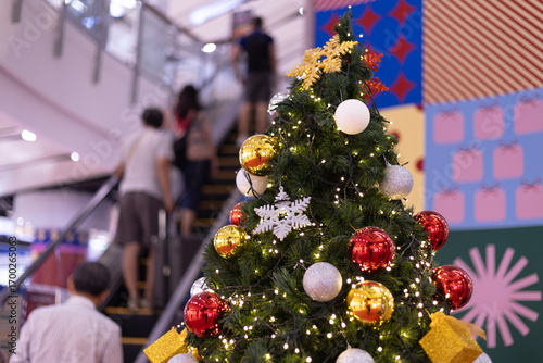 Several Christmas trees adorned with ornaments and lights brighten the evening atmosphere of a festive event shop inviting people to gather and celebrate