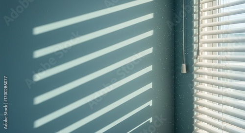 Window Blinds Casting Light Stripes on Blue Wall in Bright Room