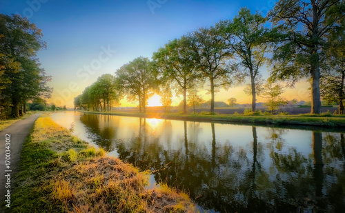 A peaceful river scene captured at dawn, showcasing vibrant colors and stunning tranquil reflections on water