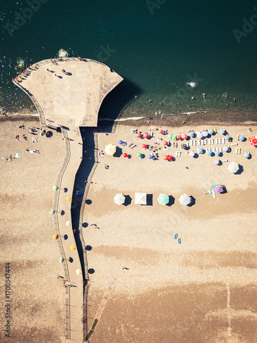 Batumi, Georgia - 15th august, 2025: Aerial top view of Batumi Georgia beach with pier bridge, colorful umbrellas, sunbathers and Black Sea coastline in summer