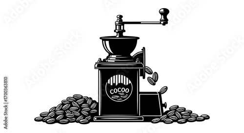 A vintage coffee grinder with a handle, beans spilling out, and a pile of beans.