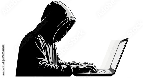 Hacker in a dark hoodie types on a laptop, side view.