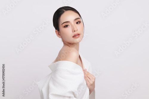 A beautiful young Asian woman with clean, fresh skin against a white background. Skincare, facial treatment, cosmetology, beauty, and spa. An elegant portrait of an Asian woman.