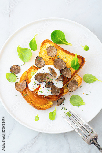 Wallpaper Mural Poached egg with black truffle on crispy buttered bread. Truffle breakfast, French cuisine, simple gourmet recipes. Autumn gourmet cuisine of Piedmont, Northern Italy, France, Spain Torontodigital.ca