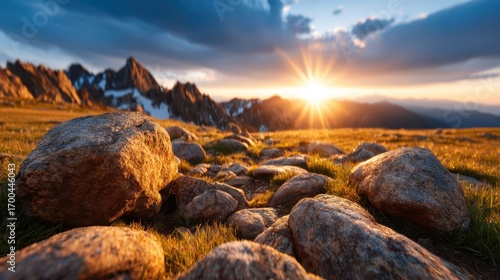 Breathtaking view of a sunset illuminating a rocky mountain terrain with stunning golden rays casting a serene ambiance over nature's majestic beauty and tranquility.