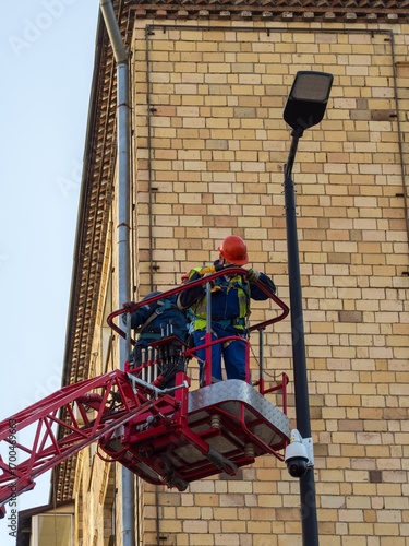 Electricians install lighting and video surveillance systems on the city street