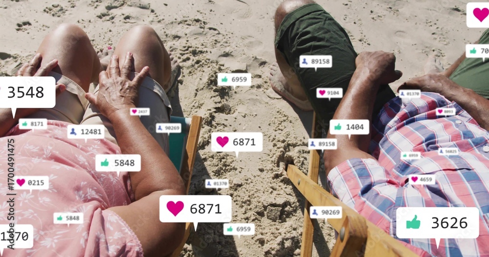 Fototapeta premium Relaxing senior couple reclining on beach chairs on sand, with floating heart and thumbs-up icons