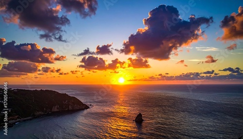 Dramatic sunset over a tranquil ocean coastline, with vibrant colors and dramatic clouds.