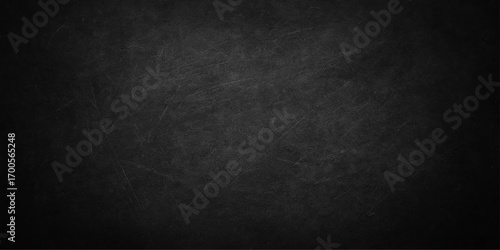 Old, dirty black paper texture with a blank, dark grunge wall background and a vintage black and white chalkboard pattern