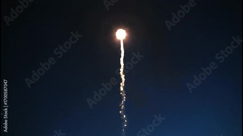 A single firework rocket ascends into the dark night sky, leaving a trail of sparks and smoke.