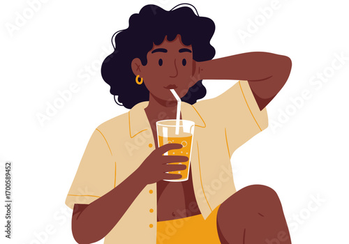 A person drinking orange juice with a straw wearing a tan shirt and gold earrings