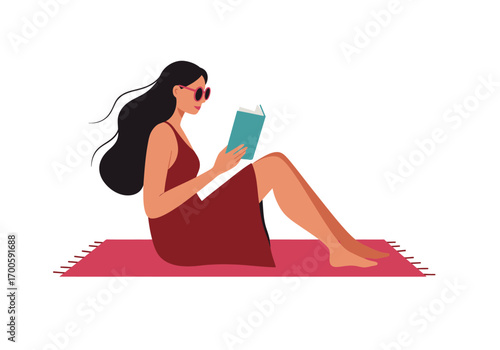 Woman in sunglasses reading a teal book on a pink fringed mat