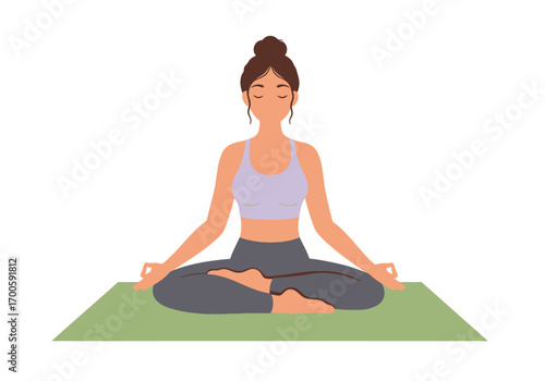 Yoga posture a woman sits crosslegged on a green mat hands in mudras eyes closed and her hair up in a bun