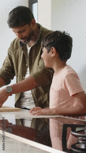 Preparing sandwiches, Indian father and son working on marble kitchen countertop with cutting board