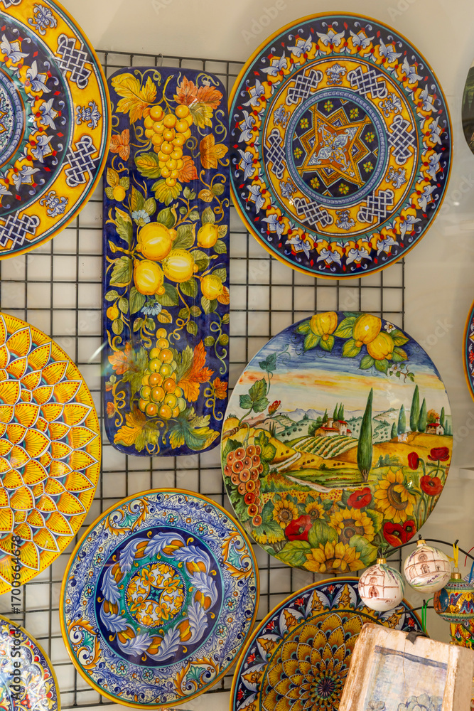 Obraz premium Traditional Italian ceramics with vibrant colors and detailed patterns, showcased in a shop in Assisi, Umbria