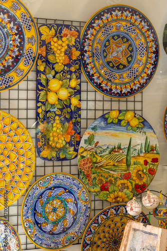 Traditional Italian ceramics with vibrant colors and detailed patterns, showcased in a shop in Assisi, Umbria