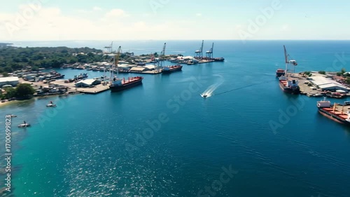 Aerial View of Port Moresby Harbor and Coastline - An aerial shot showcases Port Moresby's harbor, with cargo ships and cranes visible.