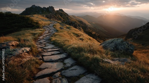 Fototapeta Naklejka Na Ścianę i Meble -  Stone paved path winds through a grassy mountain ridge under dramatic sky at sunset in Bieszczady National Park, Poland