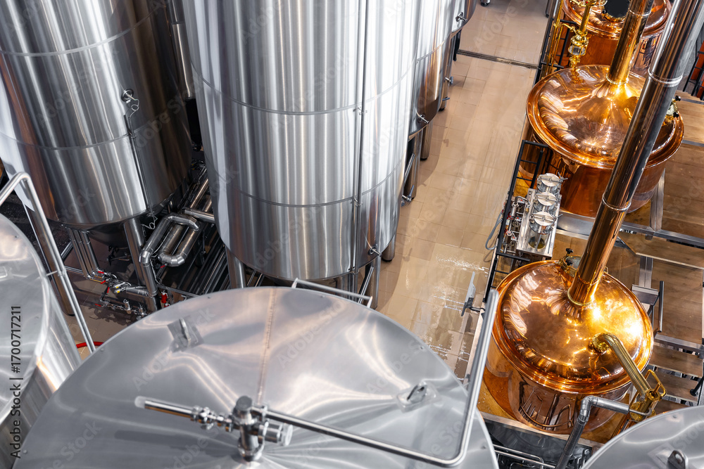 Fototapeta premium Industrial brewery facility with stainless steel tanks and copper vessels