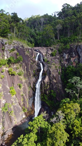Waterfall cascading down rocky cliffs in lush forest