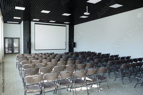 Modern conference room set for a presentation with arranged chairs and projector