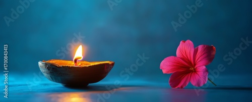 Flickering Candlelight and Vibrant Flower on Blue Background Create Serene Am...