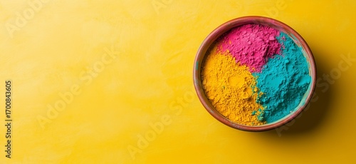 Vibrant Color Powders in a Bowl on a Bright Yellow Background During Festival...
