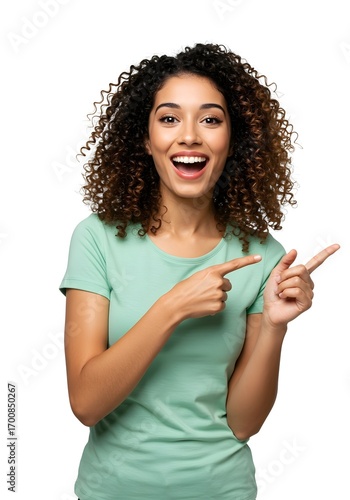 Delighted woman with curly hair making double pointing gesture in green t-shirt expressing joy and enthusiasm