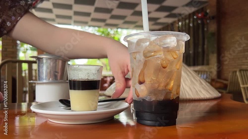 the process of making vietnamese coffee with condensed milk Making Vietnamese coffee with condensed milk in a traditional filter on a table in a cafe slow motion close-up