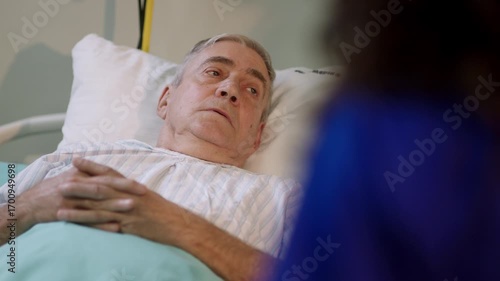 An elderly patient resting in a hospital bed, receiving medical care and attention.